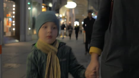 Niño-Caminando-Con-Su-Madre-En-Las-Calles-De-La-Ciudad-Por-La-Noche.