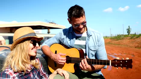 hombre tocando la guitarra para mujer 4k