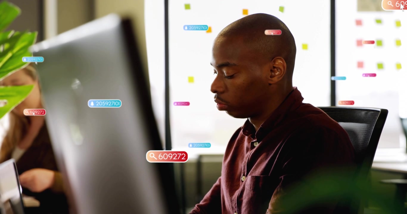 Man typing at tech desk starting floating search icons and number tags clustering then dispersing
