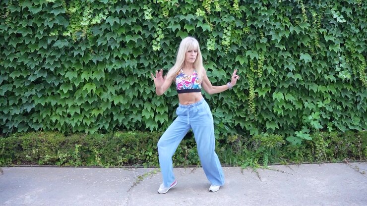 Stylish young woman in urban outfit against ivy wall exuding confidence and trendy lifestyle