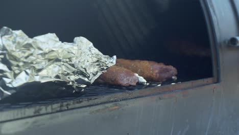 un chef coloca las estanterías de cordero con especias en la parrilla de la barbacoa para fumar