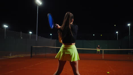 woman playing tennis at night