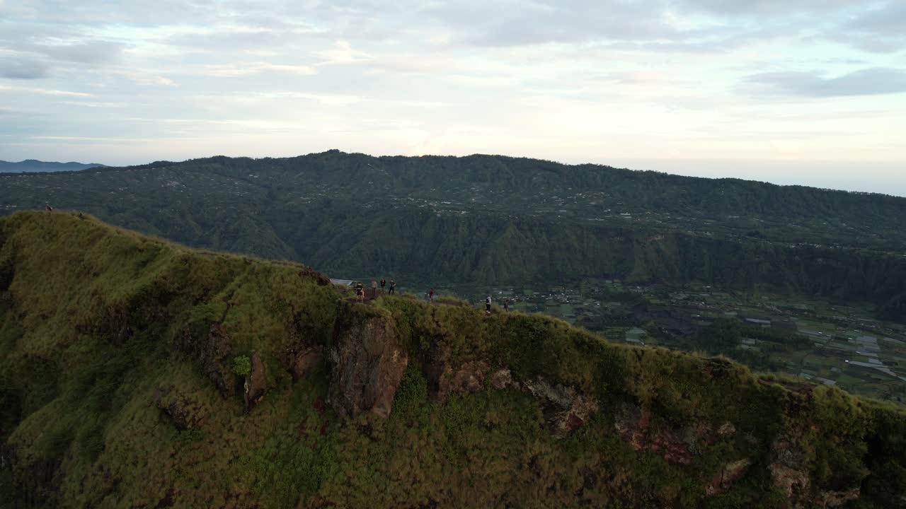 Udara orang-orang mendaki di punggung bukit dekat kawah Gunung Berapi Batur saat matahari terbit di Bali Indonesia