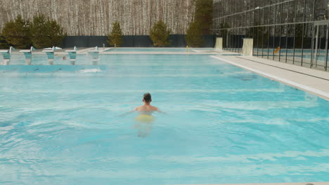 niño nadando en una moderna piscina al aire libre