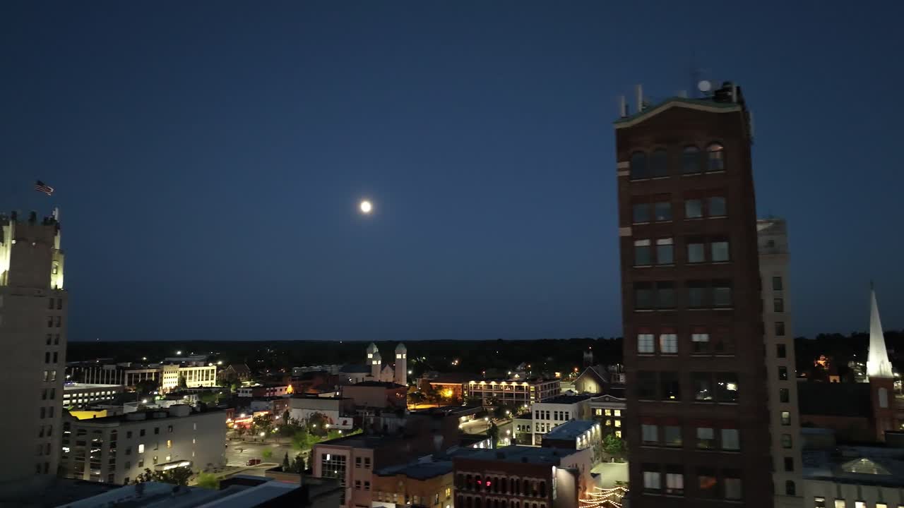 jackson, centro de michigan por la noche con un video de dron de cerca con la luna moviéndose de derecha a izquierda