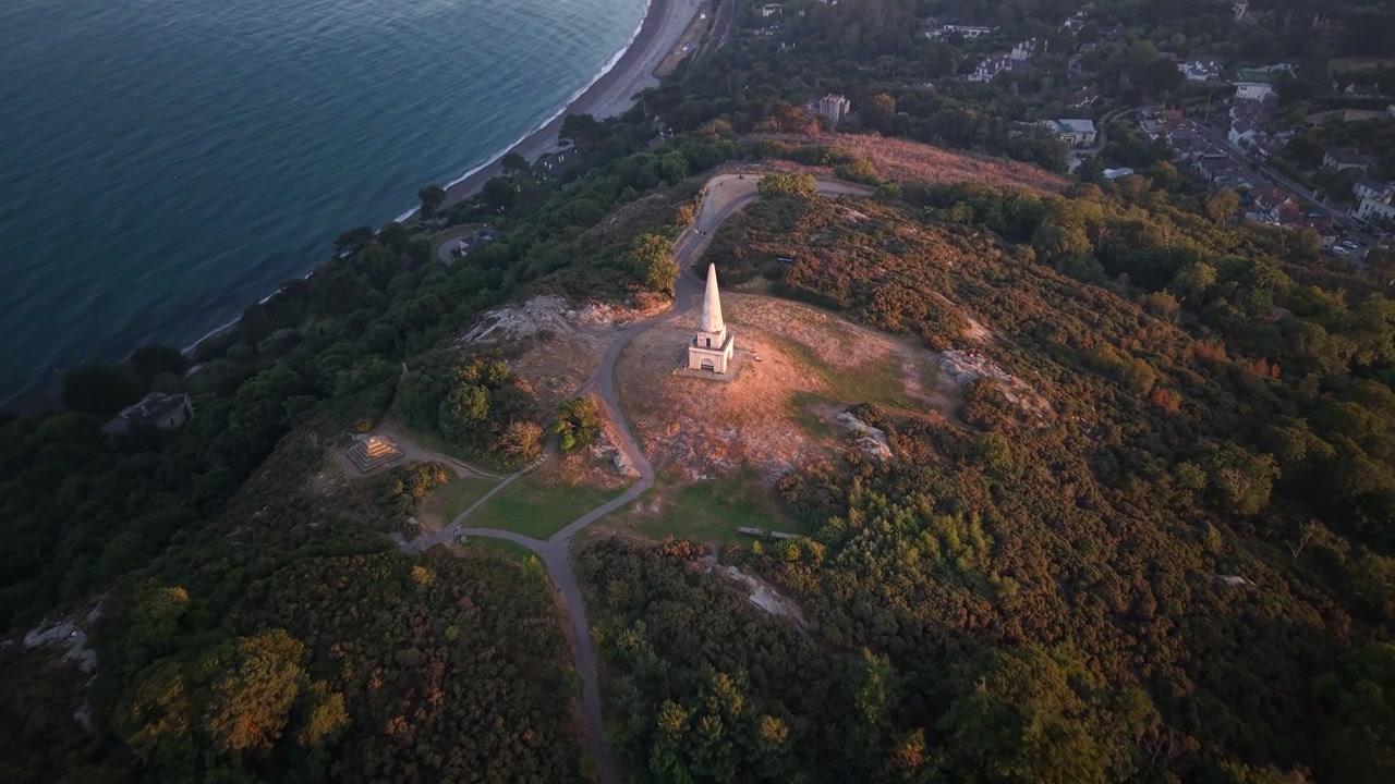 High drone perspective over Killiney Hill monument and Dublin coastline during vibrant sunset