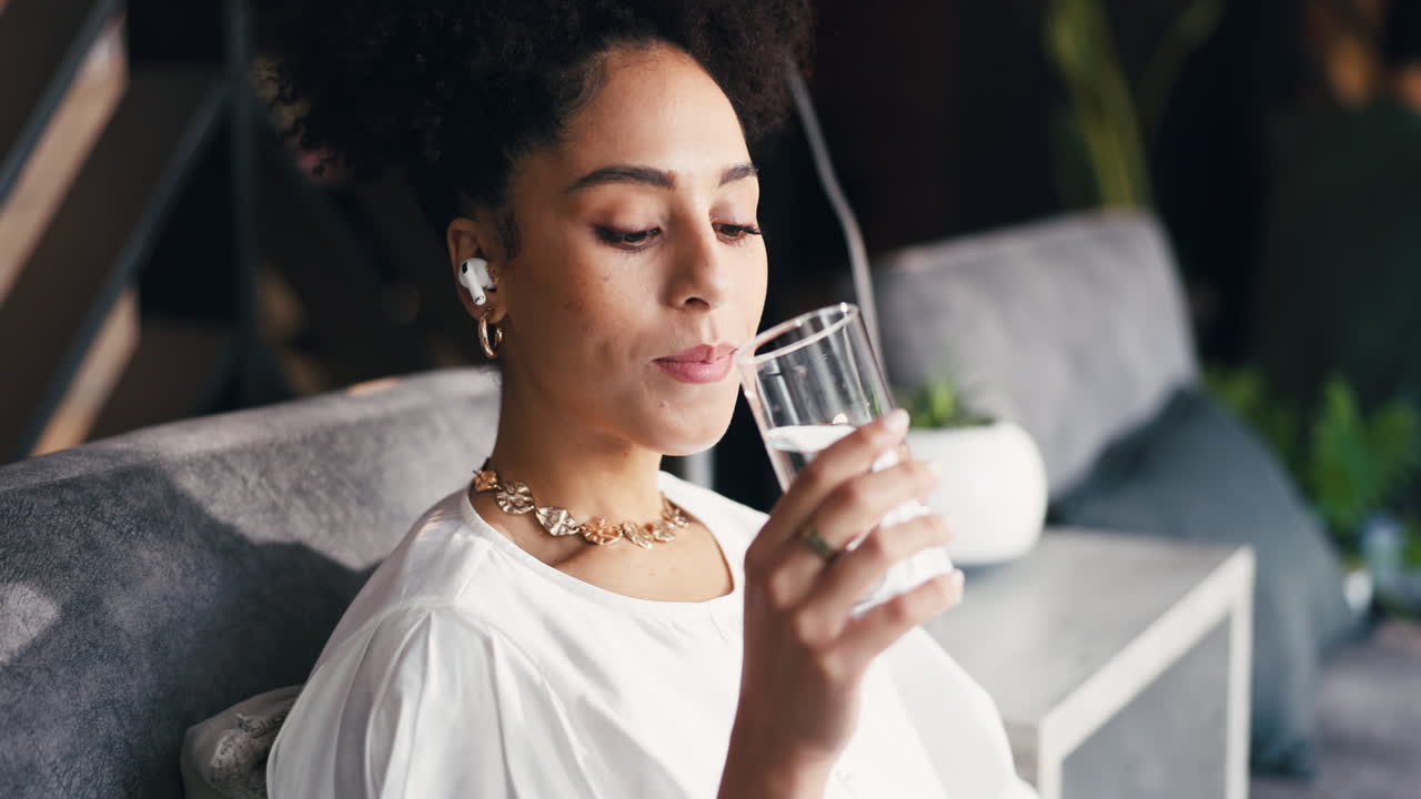 Young Woman Drinking Water and Listening with Earbuds