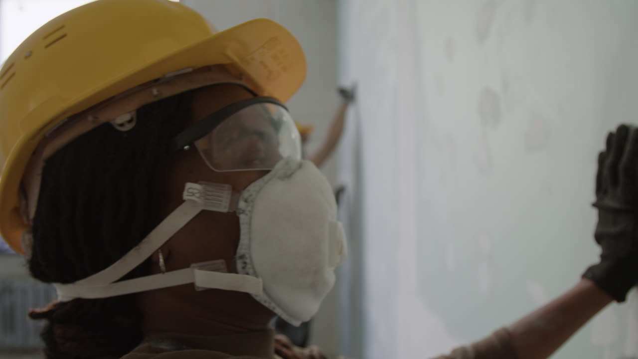 Construction workers painting a wall