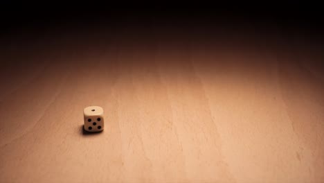 a single white dice rolling in a spotlight