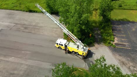 Luftaufnahme-Eines-Feuerwehrautos-Mit-Vollständig-Ausgefahrenem-Leiterschlauch-Während-Der-Durchführung-Von-Übungsübungen