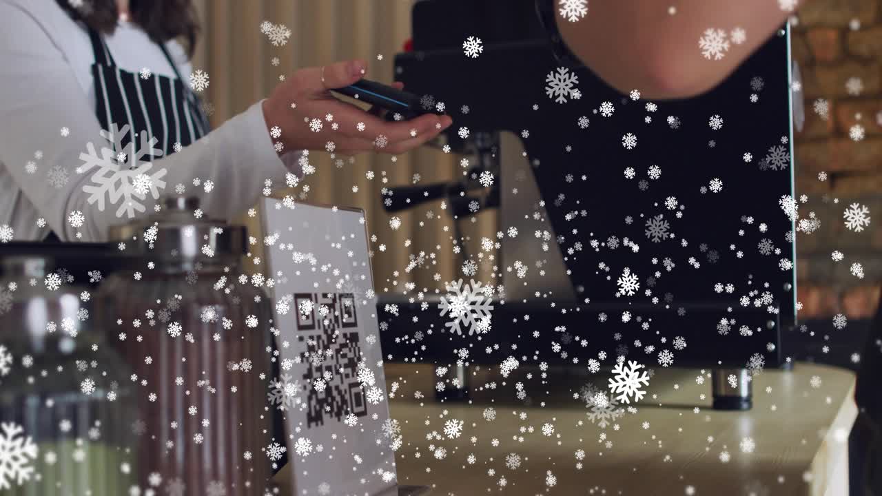 Barista holding POS by QR sign at cafe, customer tapping phone, completing sale under snow overlay