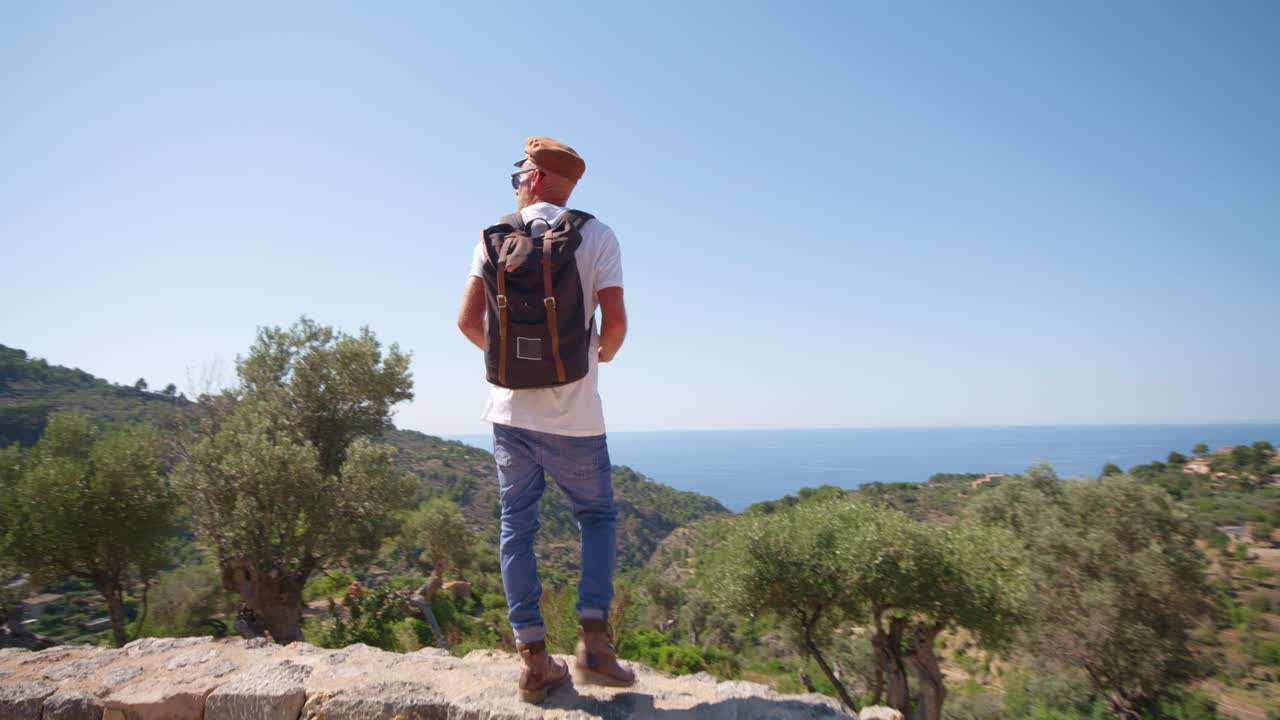 Traveler adult man near sea coast admiring mountain view