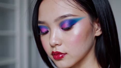close-up portrait of a woman with bold and colorful artistic makeup