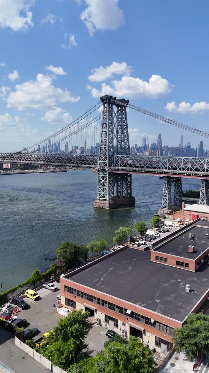 A stunning drone shot showcasing the Williamsburg Bridge in Brooklyn with a vertical push-in reveal, highlighting the structure and the surrounding cityscape along the East River.