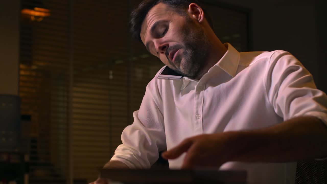 Uomo serio che parla al cellulare nel suo ufficio