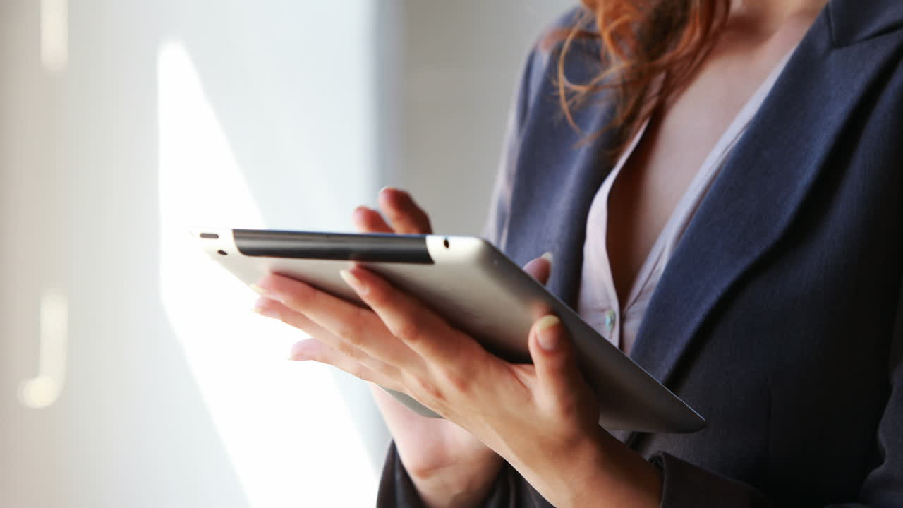 mujer de negocios usando su tableta junto a la ventana