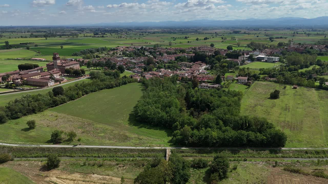 Il piccolo insediamento rurale di Chignolo e il complesso del Castello Procaccini situati tra le pianure coltivate della Valle del Po, siepi e corridoi di irrigazione nella Provincia di Pavia, Lombardia, Italia.