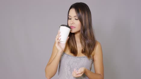 attractive young woman drinking takeaway coffee