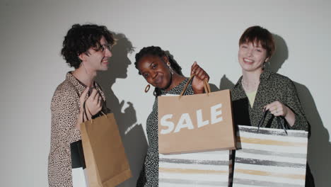 Happy-Multiethnic-Friends-Posing-with-Shopping-Bags-in-Studio