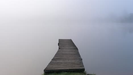 Muelle-Brumoso-En-Niebla-Intensa---Escena-De-Mano-Espeluznante---Delgado-Muelle-De-Madera-En-La-Cabaña-De-Ontario