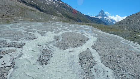 Fliegen-Sie-Nah-über-Den-Findelgletscher-Und-überfluten-Sie-Die-Ebene-In-Der-Schweiz-Mit-Dem-Majestätischen-Matterhorn-Gipfel-Im-Hintergrund---FPV-Drohne-Aufnahme