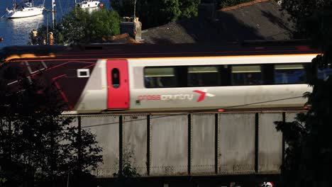 crosscountry railway train crosses the royal albert bridge arriving at saltash train station in cornwall