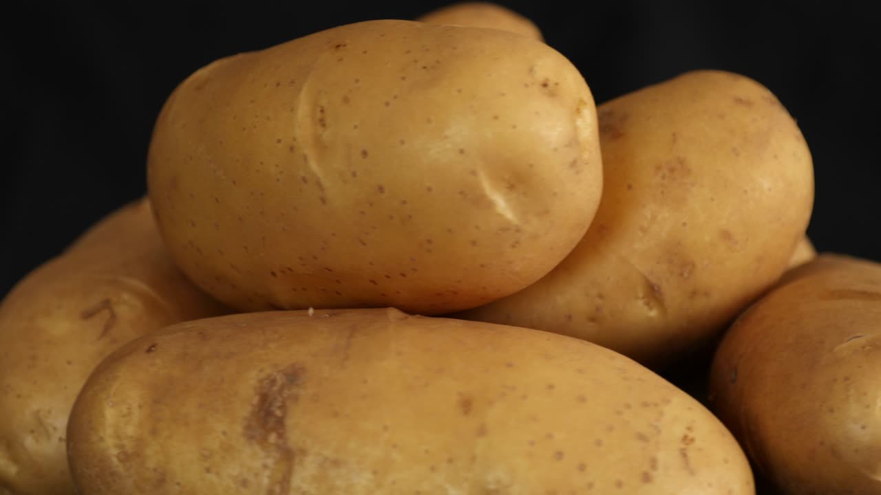 patatas crudas que giran y giran aisladas sobre un fondo negro 2