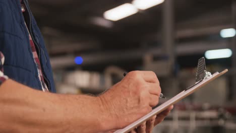 male worker maintaining records on clipboard