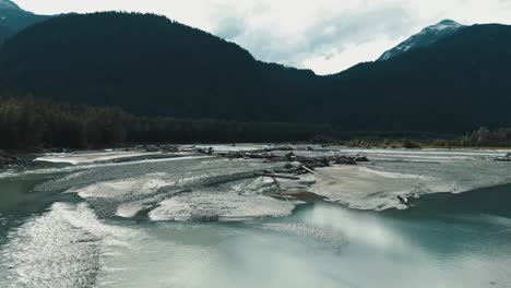 Close-up-4K-cinematic-view-of-the-Squamish-River,-capturing-the-intricate-details-of-the-flowing-water-and-surrounding-foliage