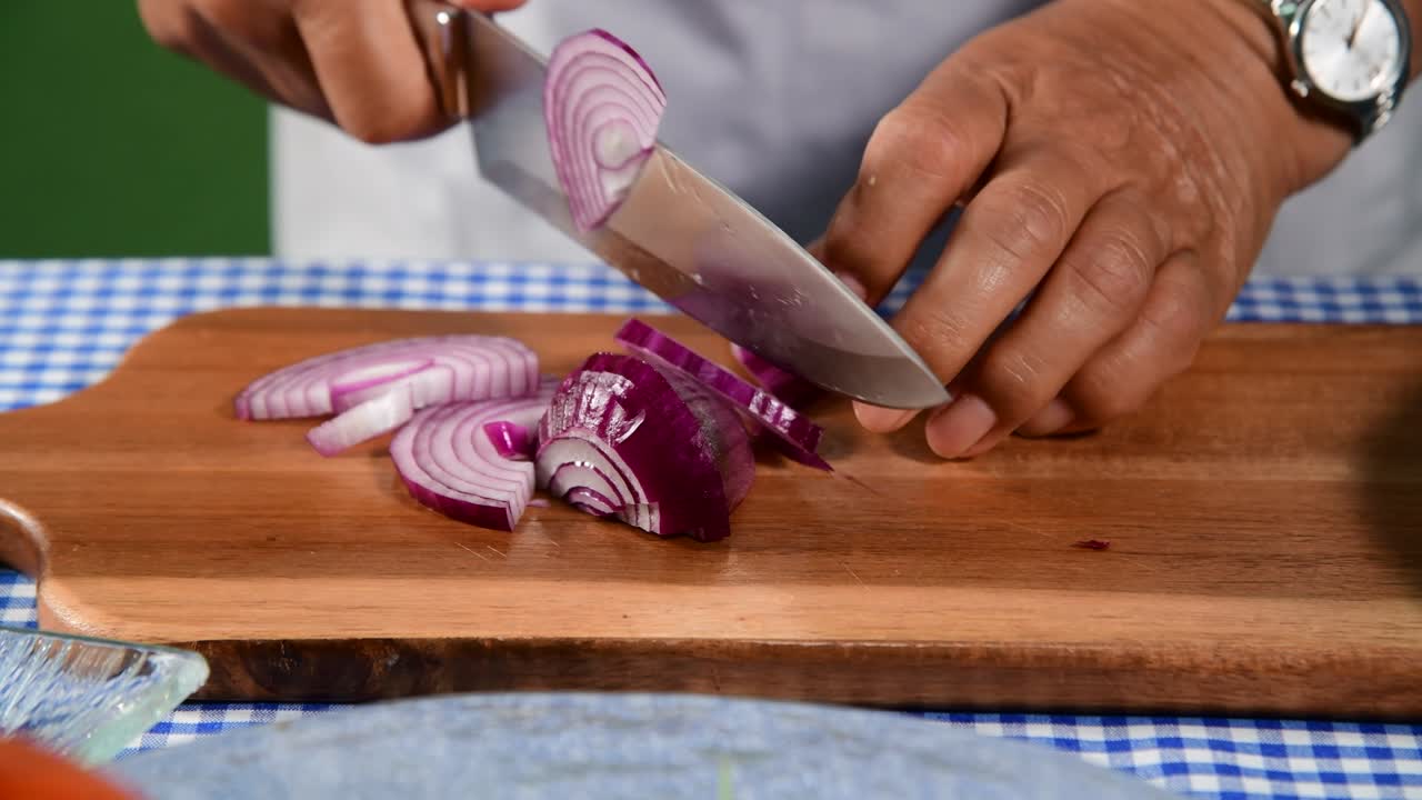 cutting red onion on wooden board  woman hand cutting red onion on the table