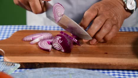 cortando cebolla roja en una tabla de madera mujer cortando cebola roja a mano en la mesa