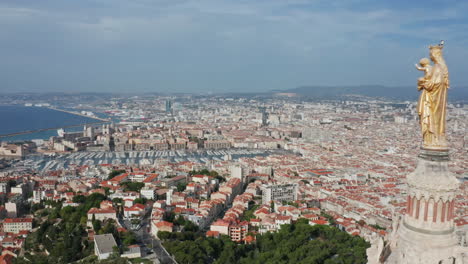 close up aerial footage of statue on top of notre dame de la guard basilica in marseille france