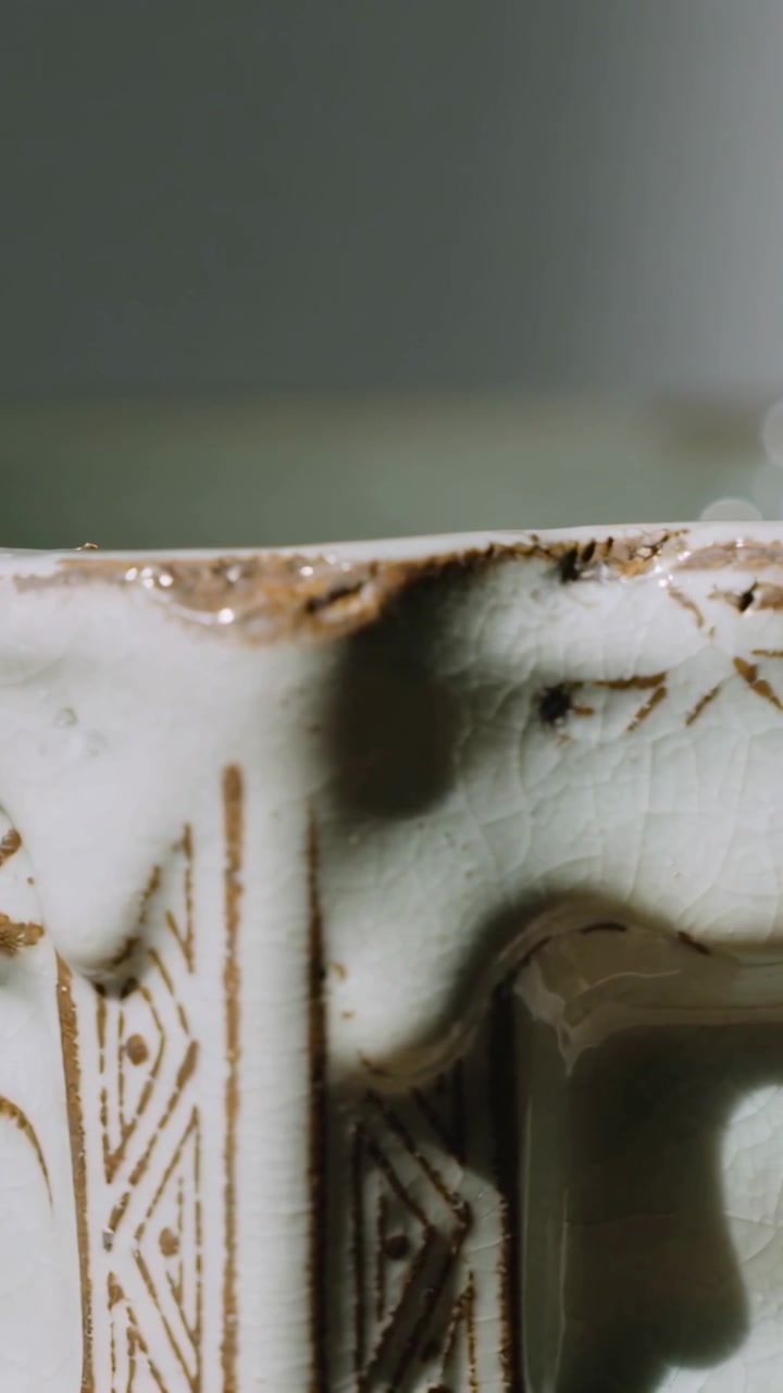 Video verticale: Telecamera che si sposta rivelando il bordo di un piatto di ceramica su un tavolo, mostrando una scheggiatura e delle screpolature.