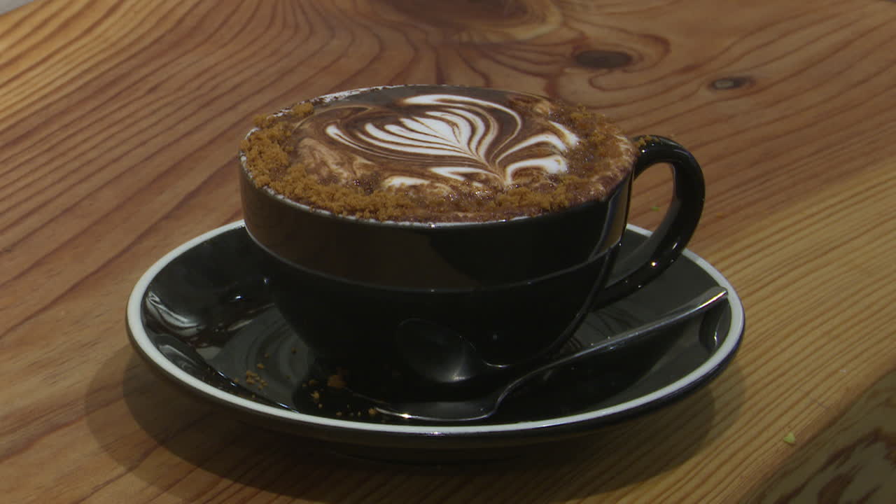 Delicious Cappuccino with Latte Art on a Wooden Table