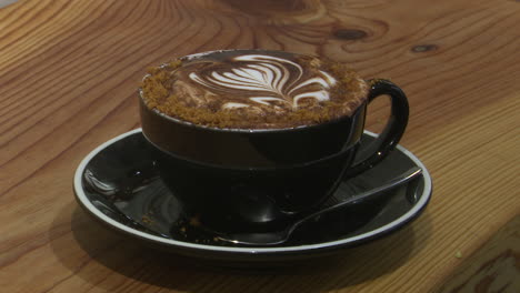 delicious cappuccino with latte art on a wooden table
