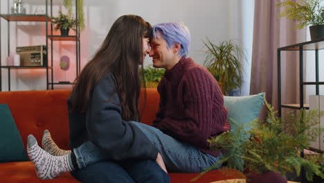 close-up portrait of two young lesbian women family couple, girls embrace, hug each other at home