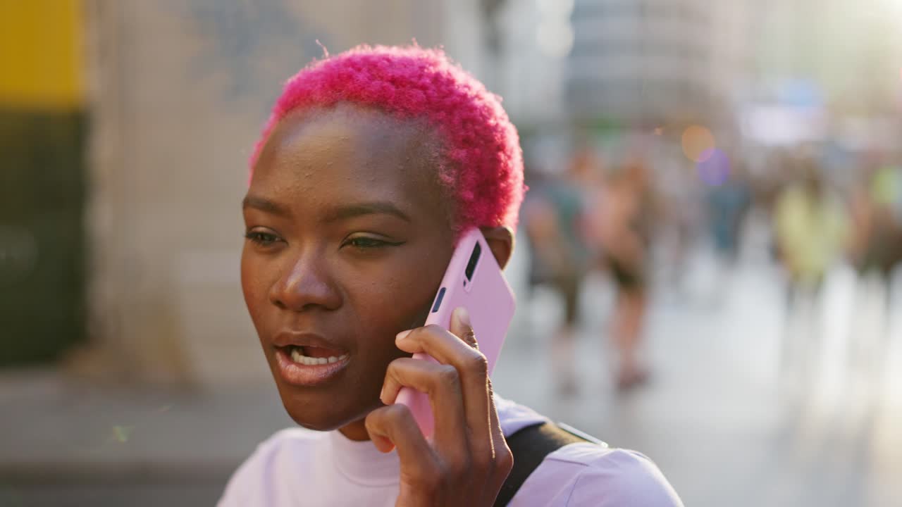 Young Woman with Pink Hair Talking on Phone in Urban Setting