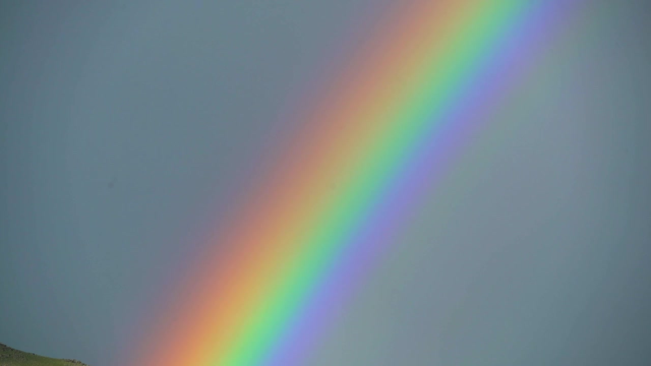 L'arcobaleno vibrante che attraversa un cielo nuvoloso