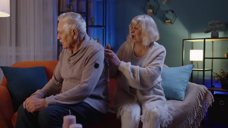 hombre mayor se sienta con su esposa en el interior se siente molesto, potencia problemas de salud, crisis, impotencia, enfermedad