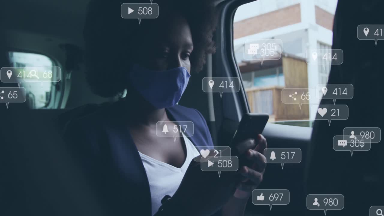 animación de iconos de las redes sociales sobre una mujer afroamericana que usa una máscara usando un teléfono inteligente en el coche