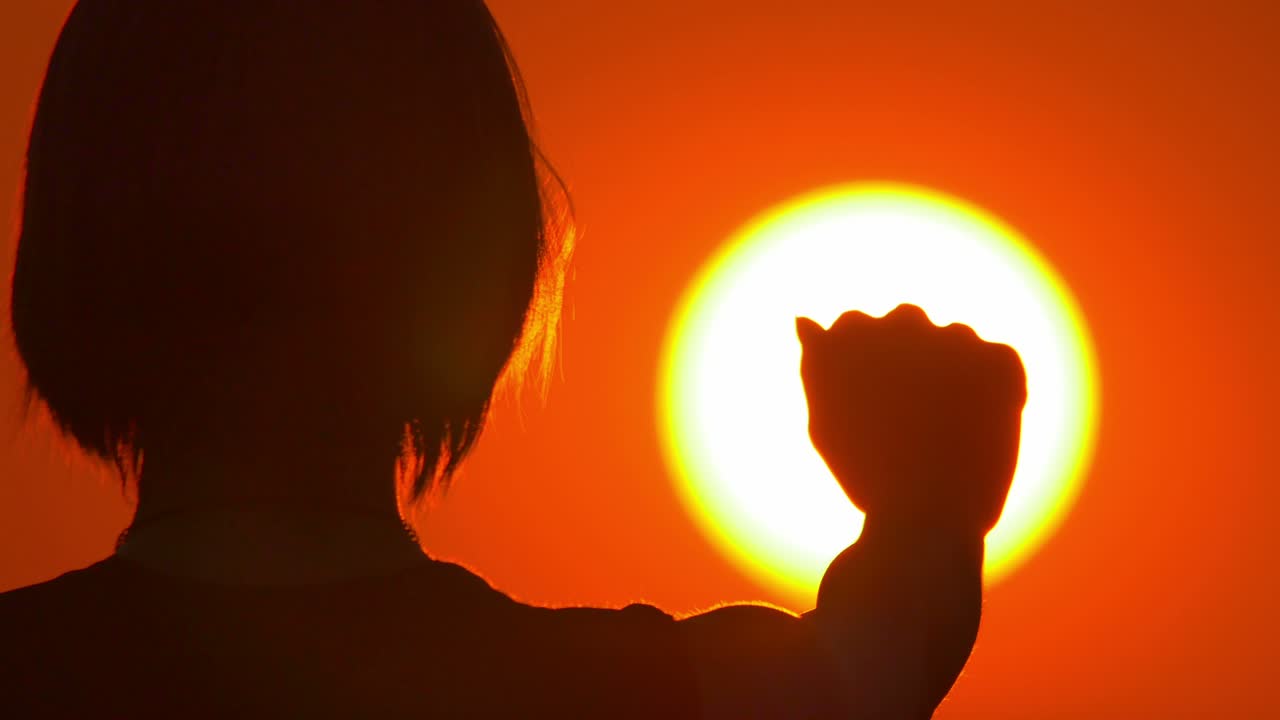 여성 (실루) 은 밝은 태양과 하늘 배경에 서 있습니다. 가게