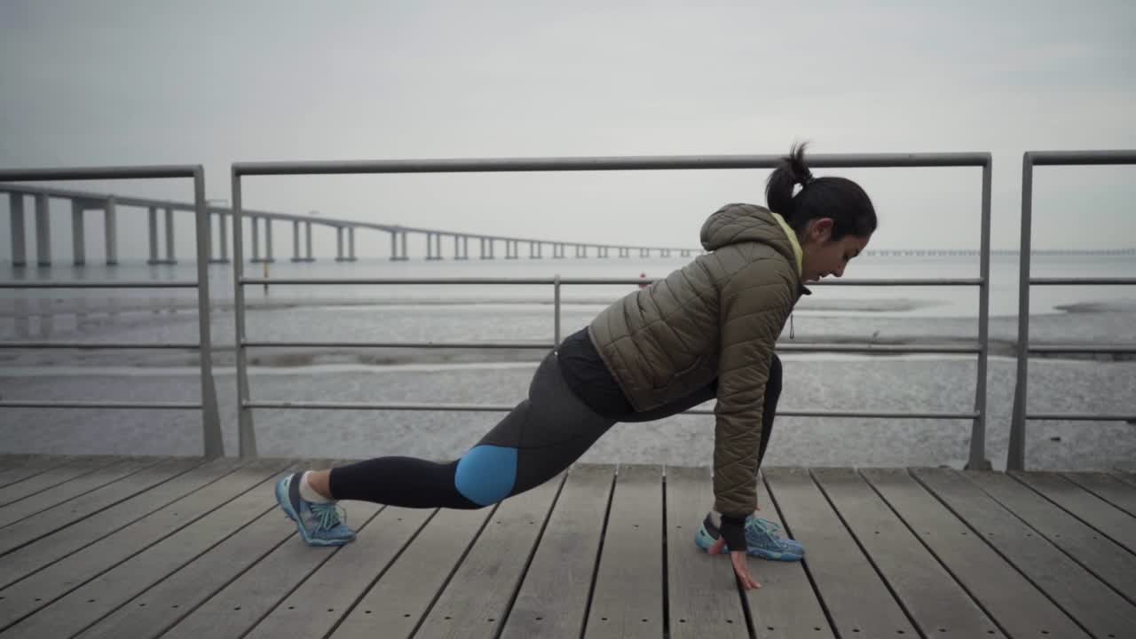 Concentrated young brunette warming up before workout