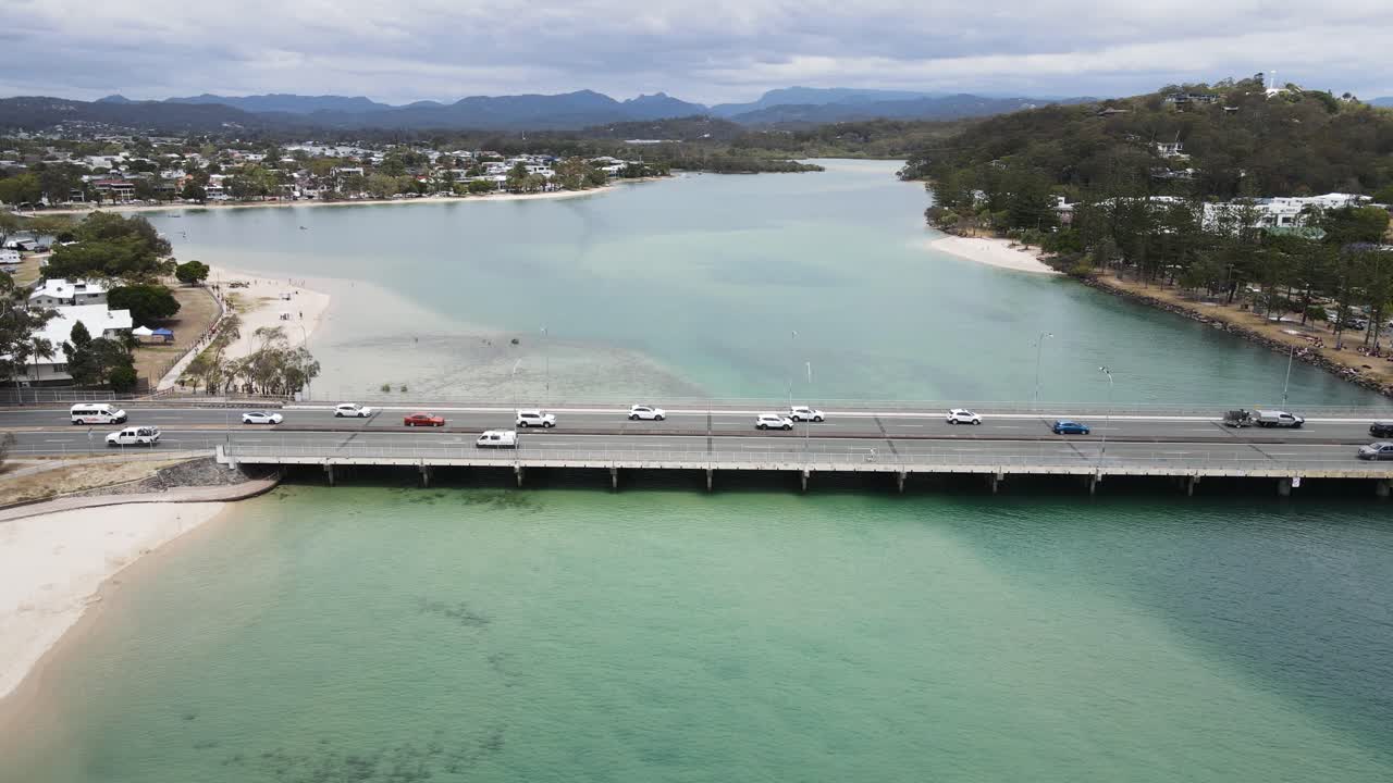 Veduta drone unica che segue il pittoresco Tallebudgera Creek e sorvola il ponte della Gold Coast Highway