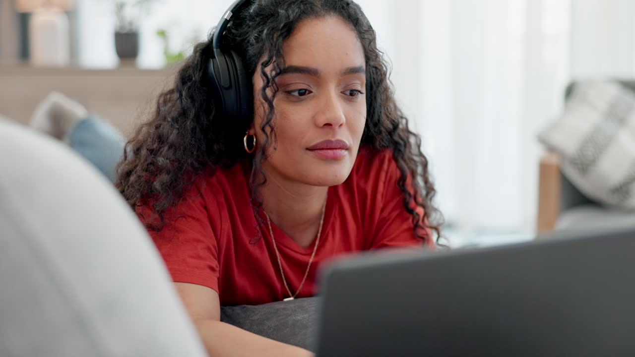 mujer feliz acostada en el sofá con una computadora portátil