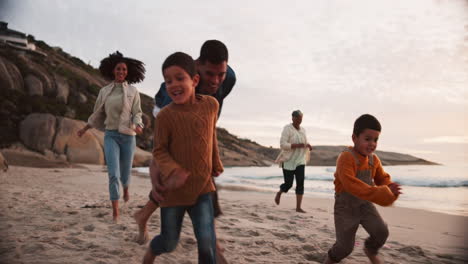 feliz, corriendo y viajando con una gran familia en la playa
