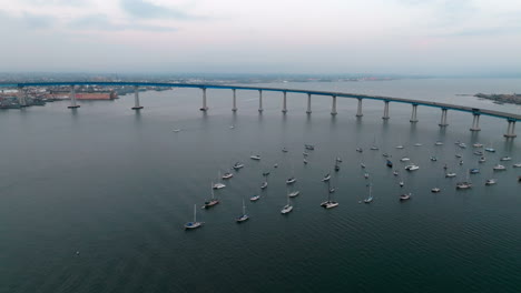 aerial overview of san diego bay with coronado bridge and marina with small boats on the surface of dark blue pacific ocean