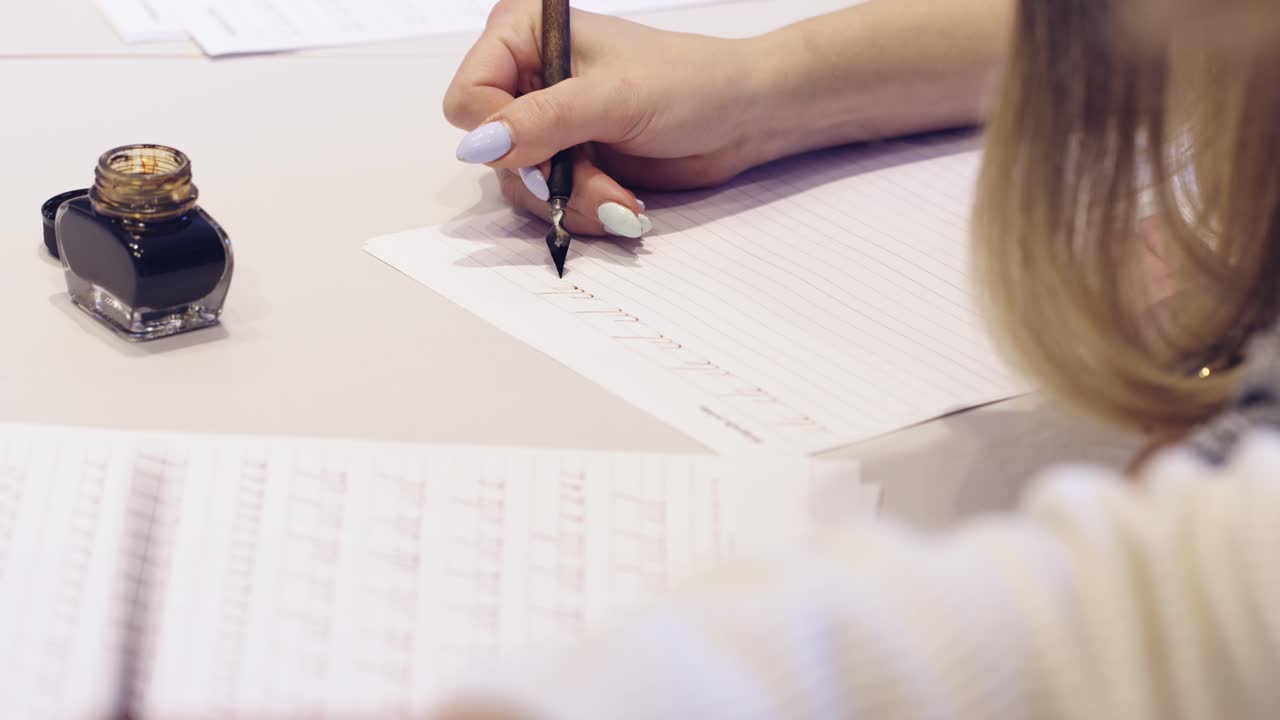 Female and writting oldschool black ink pen on the white theet of paper close  up slow motion in class room
