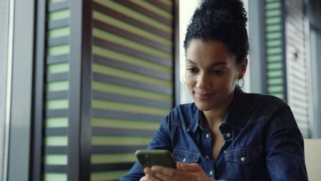 mujer usando un teléfono inteligente en un café