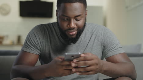 smiling man holding phone at kitchen