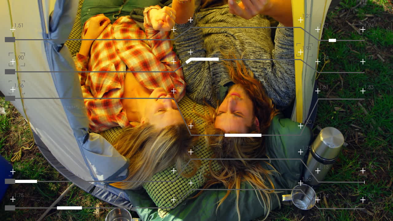 In school, two people analyzing animated data overlay on laptop screen outdoors